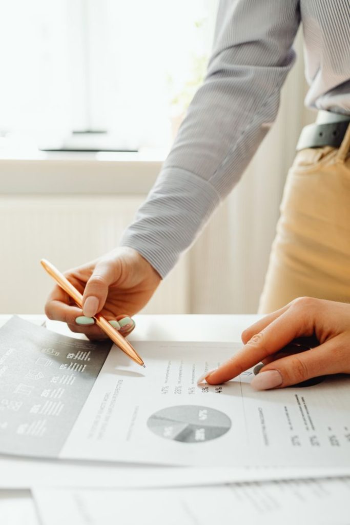 The Art of Drawing Readers In: Your attractive post title goes here Close-up of hands reviewing financial documents and graphs in an office setting.